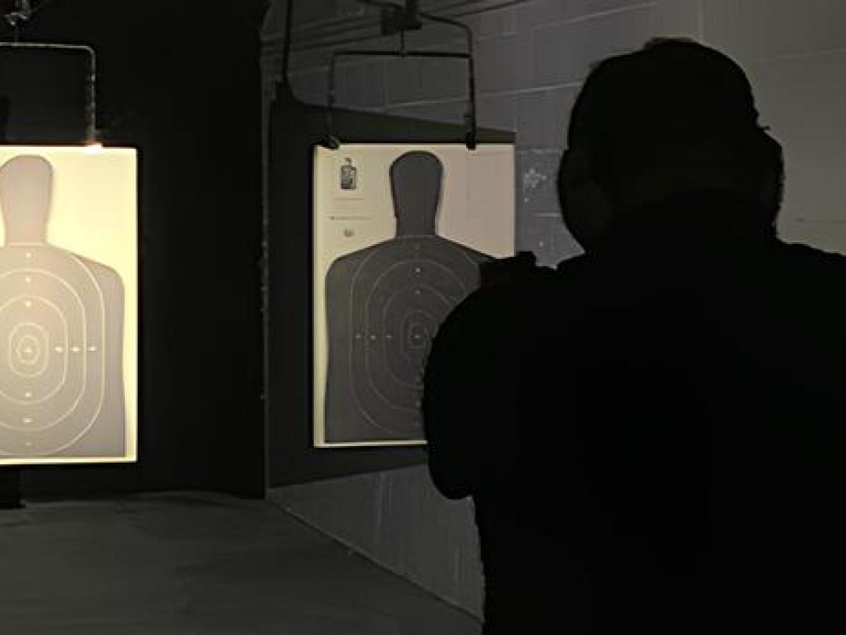 a man standing in front of a target on a shooting range